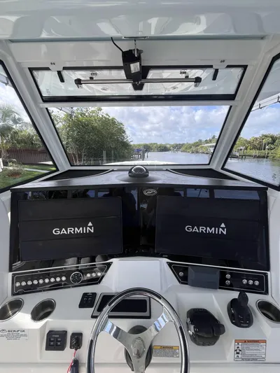  Yacht Photos Pics 2021 Sea Fox 368 Commander helm with dual Garmin displays on a scenic waterway.