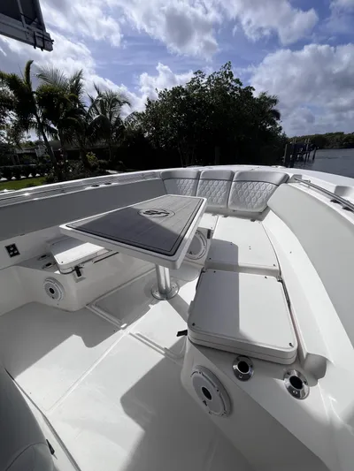  Yacht Photos Pics 2021 Sea Fox 368 Commander boat interior with seating and table, under a partly cloudy sky.