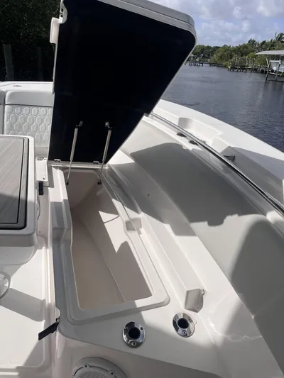  Yacht Photos Pics 2021 Sea Fox 368 Commander boat with open storage compartment, docked by a scenic waterway.