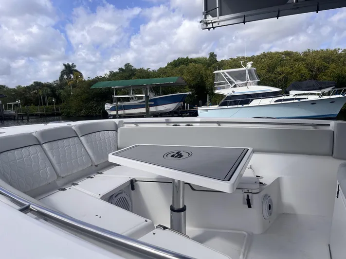  Yacht Photos Pics 2021 Sea Fox 368 Commander boat interior with seating and table, docked near other boats.