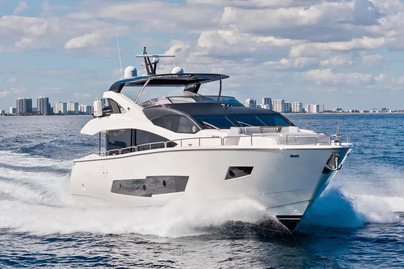 Aqua Vista Yacht Photos Pics 2019 Sunseeker 86 Yacht cruising on open water with city skyline backdrop.