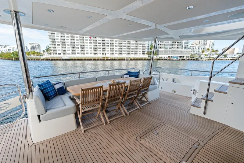 Aqua Vista Yacht Photos Pics Luxurious 2019 Sunseeker 86 Yacht deck with dining area overlooking waterfront buildings.