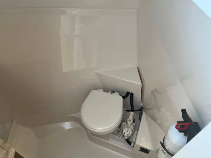  Yacht Photos Pics 2018 Pursuit DC 295 Dual Console boat interior with toilet and fire extinguisher.