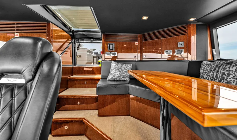 Karillian & Company Yacht Photos Pics Luxurious interior of 2018 Sunseeker 95 Yacht with sleek wood finishes and plush seating.