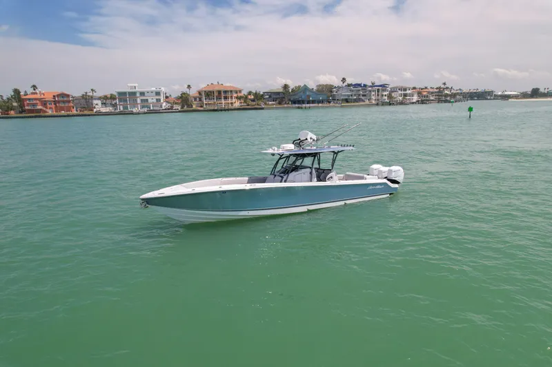 My Mermaid Yacht Photos Pics 2020 Nor-Tech 390 Sport Center Console boat on calm turquoise water near coastal homes.