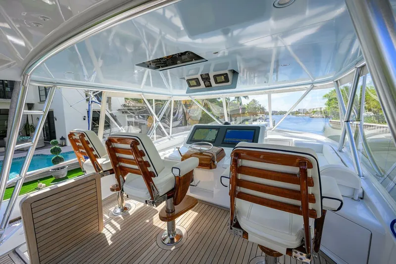 Pryorities Yacht Photos Pics Luxurious helm of 2008 Viking 60 Convertible yacht with wooden chairs and navigation screens.