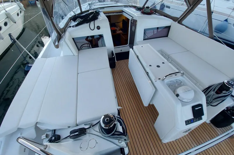 Ssy 01 Yacht Photos Pics 2021 Jeanneau Sun Odyssey 440 yacht cockpit with white seating and teak flooring.