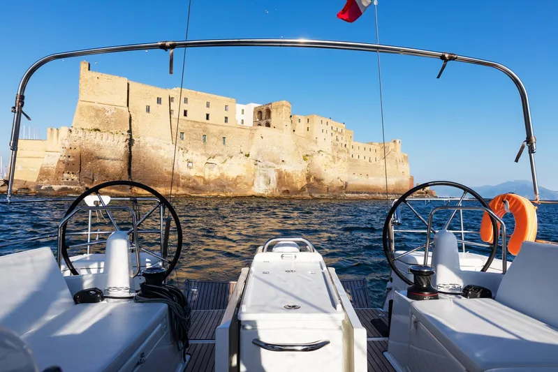 Ssy 01 Yacht Photos Pics Jeanneau Sun Odyssey 440 sailing near historic fortress, clear blue sky, 2021 model.