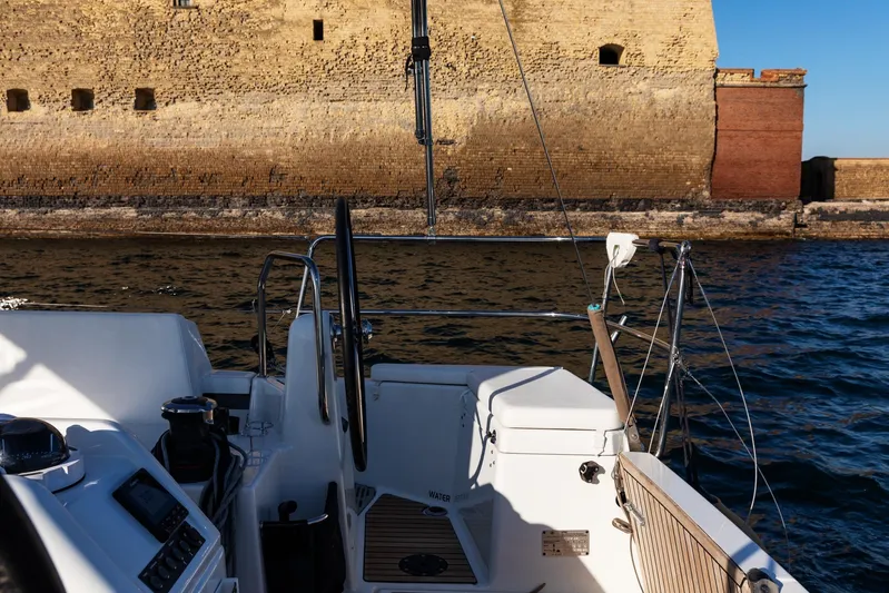 Ssy 01 Yacht Photos Pics Cockpit view of 2021 Jeanneau Sun Odyssey 440 sailing near historic stone wall.