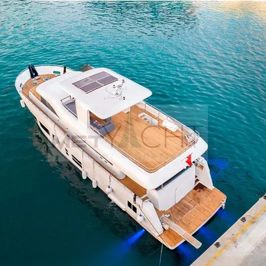 Yacht Photos Pics 2024 Custom Trawler yacht docked in clear blue water, featuring solar panels and spacious deck.