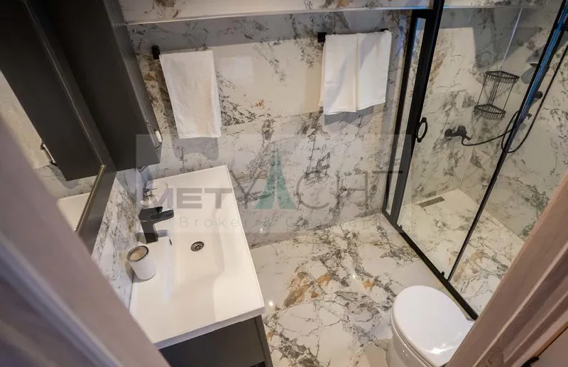  Yacht Photos Pics Luxurious bathroom in 2024 Custom Trawler with marble tiles and modern fixtures.