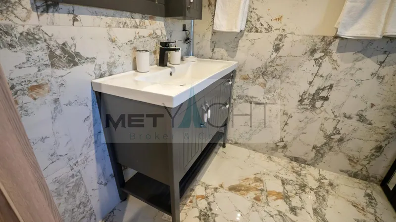  Yacht Photos Pics Modern bathroom with marble walls and floor, featuring a sleek vanity unit.