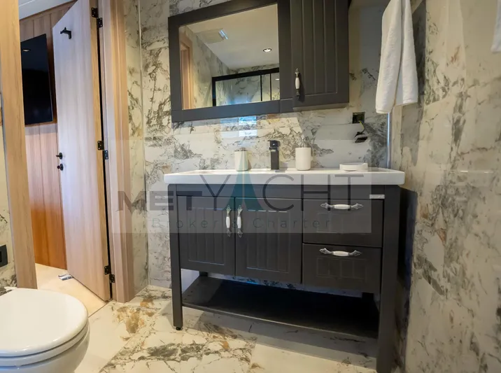  Yacht Photos Pics Luxurious bathroom on 2024 Custom Trawler with marble walls and modern vanity.