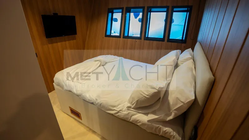  Yacht Photos Pics Cozy bedroom in 2024 Custom Trawler with wood paneling and small windows.