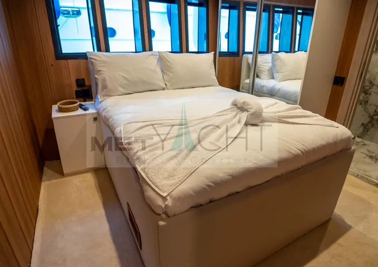  Yacht Photos Pics Luxurious bedroom interior on 2024 Custom Trawler yacht with elegant bedding and wood paneling.