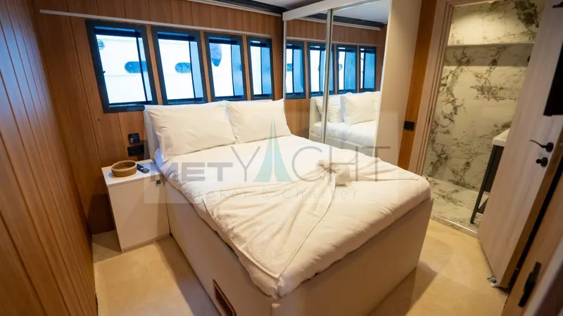  Yacht Photos Pics Luxurious 2024 Custom Trawler bedroom with double bed, wood paneling, and ensuite bathroom.