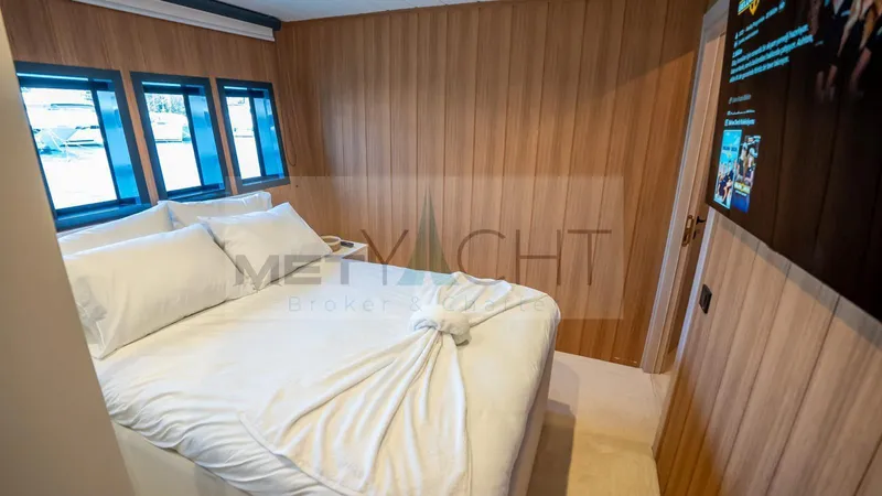  Yacht Photos Pics Luxurious 2024 Custom Trawler bedroom with wood paneling and large windows.