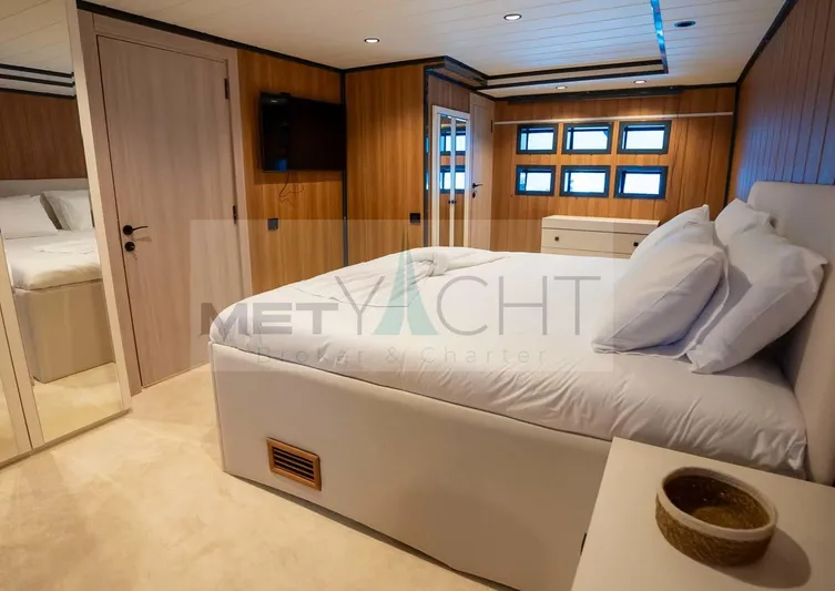  Yacht Photos Pics Luxurious 2024 custom trawler bedroom with wood paneling and modern furnishings.