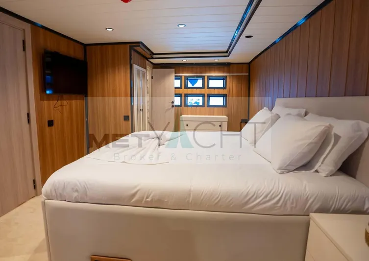  Yacht Photos Pics Luxurious 2024 Custom Trawler bedroom with wood paneling and modern amenities.