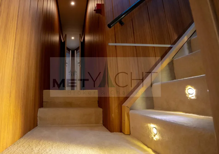  Yacht Photos Pics Interior of 2024 Custom Trawler yacht with wooden walls and carpeted stairs.