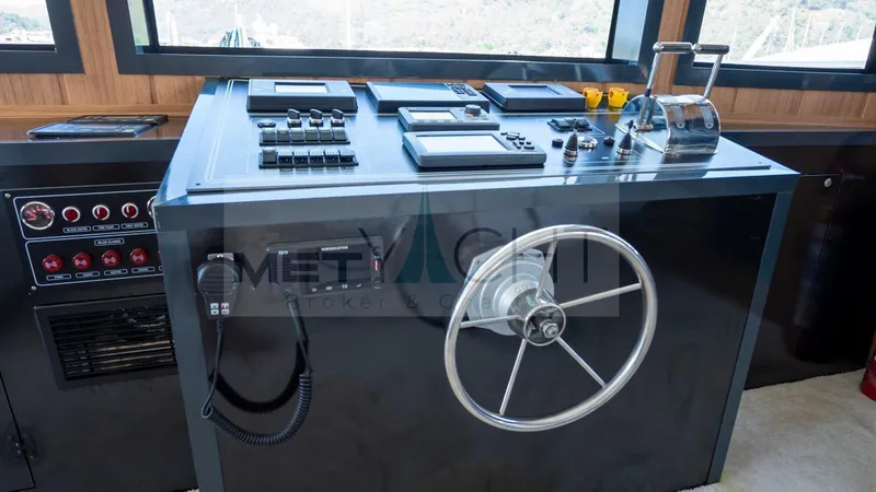  Yacht Photos Pics Control panel of a 2024 Custom Trawler with steering wheel and navigation instruments.