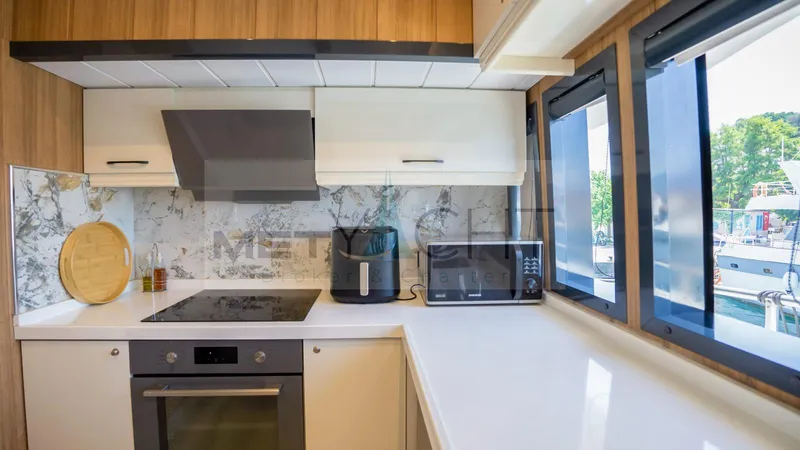  Yacht Photos Pics Modern kitchen in 2024 custom trawler with sleek appliances and large windows.