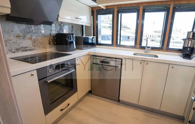  Yacht Photos Pics Modern kitchen interior on 2024 Custom Trawler yacht with sleek appliances and ample natural light.