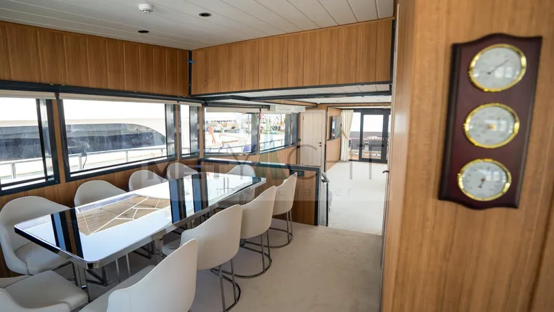  Yacht Photos Pics Luxurious interior of a 2024 custom trawler with elegant dining area and panoramic windows.