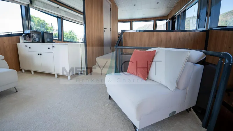  Yacht Photos Pics Luxurious interior of 2024 Custom Trawler yacht with modern furnishings and large windows.