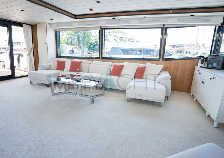  Yacht Photos Pics Luxurious 2024 custom trawler interior with white sofa, red cushions, and large windows.
