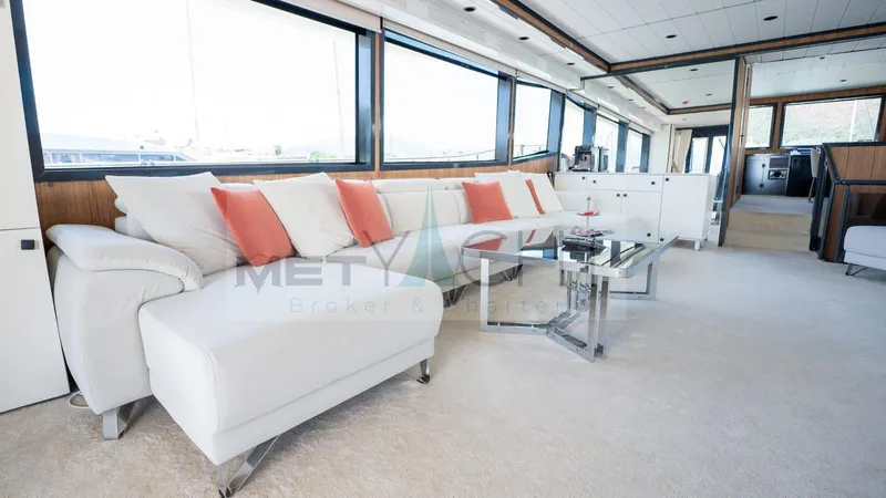  Yacht Photos Pics Luxurious 2024 custom trawler interior with white and coral accents, spacious seating, and large windows.