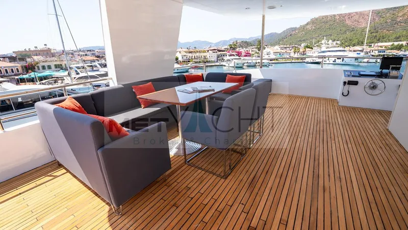  Yacht Photos Pics Luxurious 2024 Custom Trawler yacht deck with seating, table, and scenic marina view.