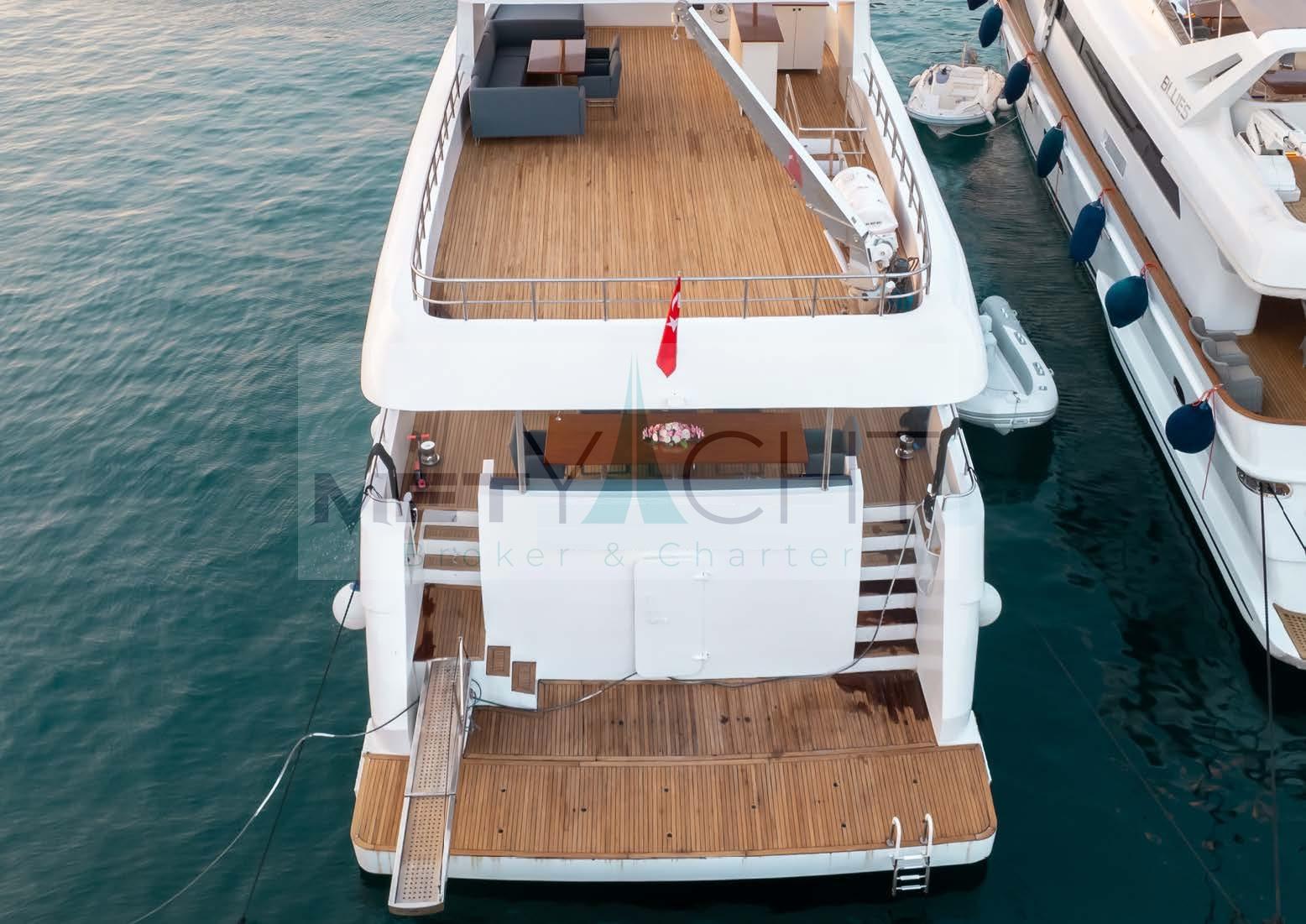 Custom 2024 Trawler yacht with spacious deck, docked alongside another vessel.