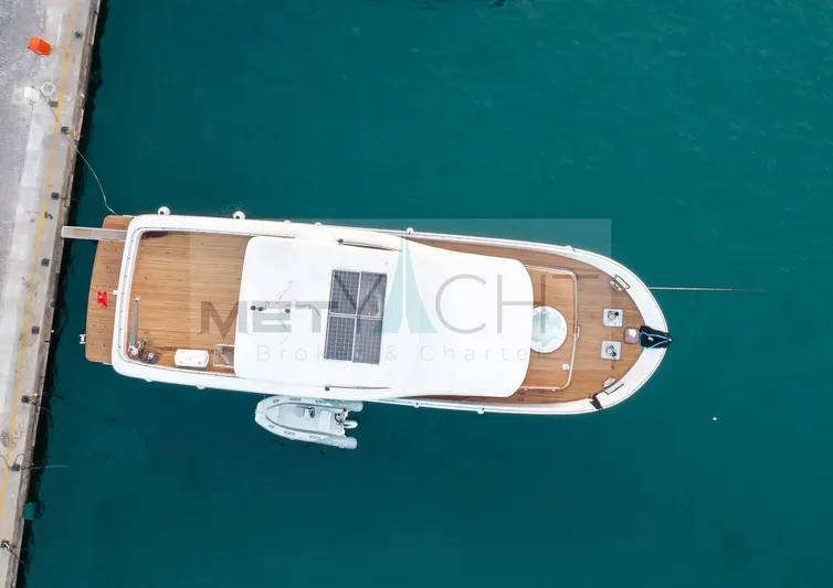  Yacht Photos Pics Aerial view of 2024 Custom Trawler docked in clear blue water.