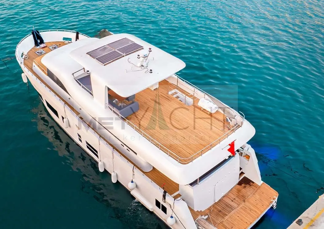 Custom 2024 Trawler yacht with solar panels docked on clear blue water.