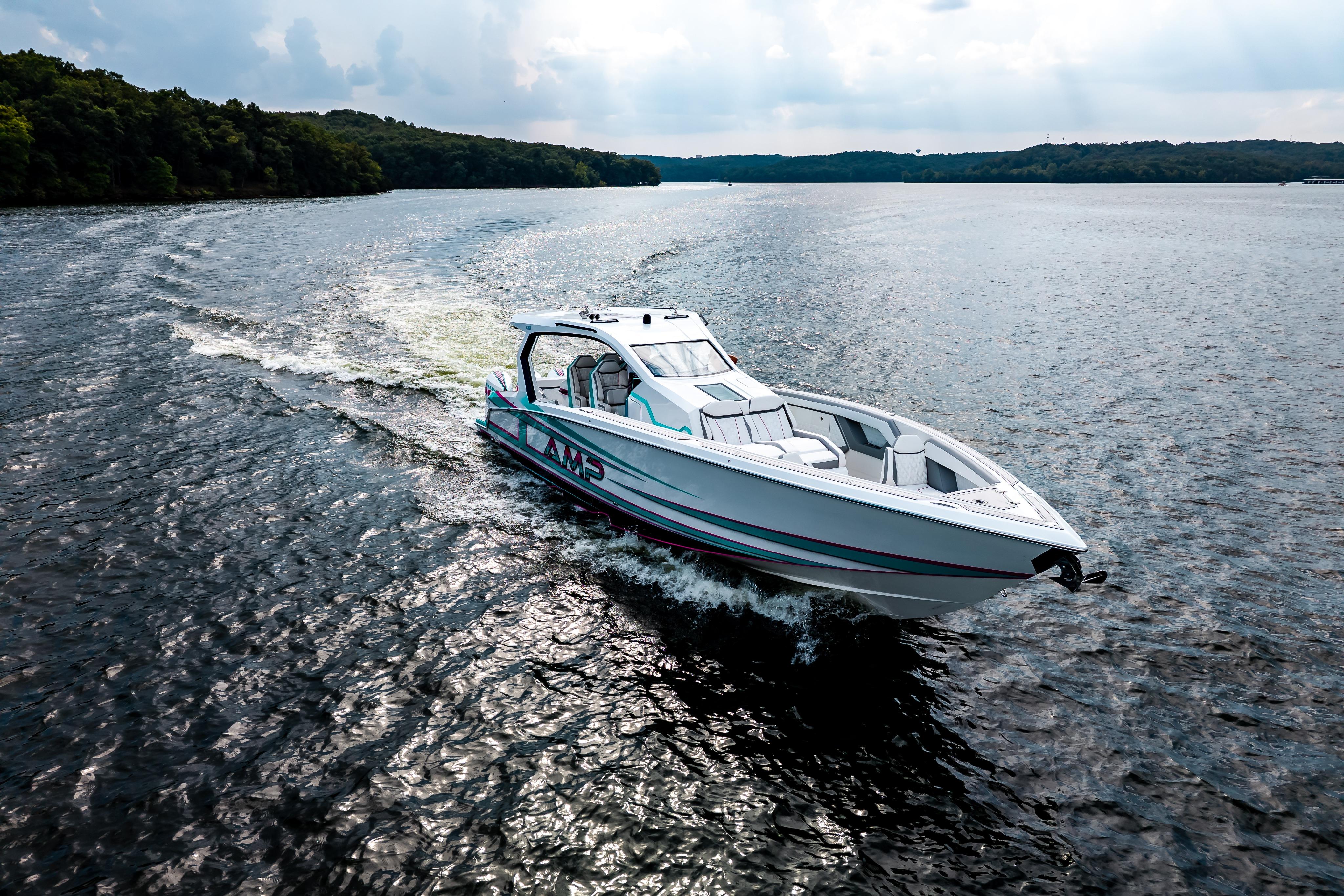 A sleek AMP 443 boat cruising on a scenic lake, 2025 model.