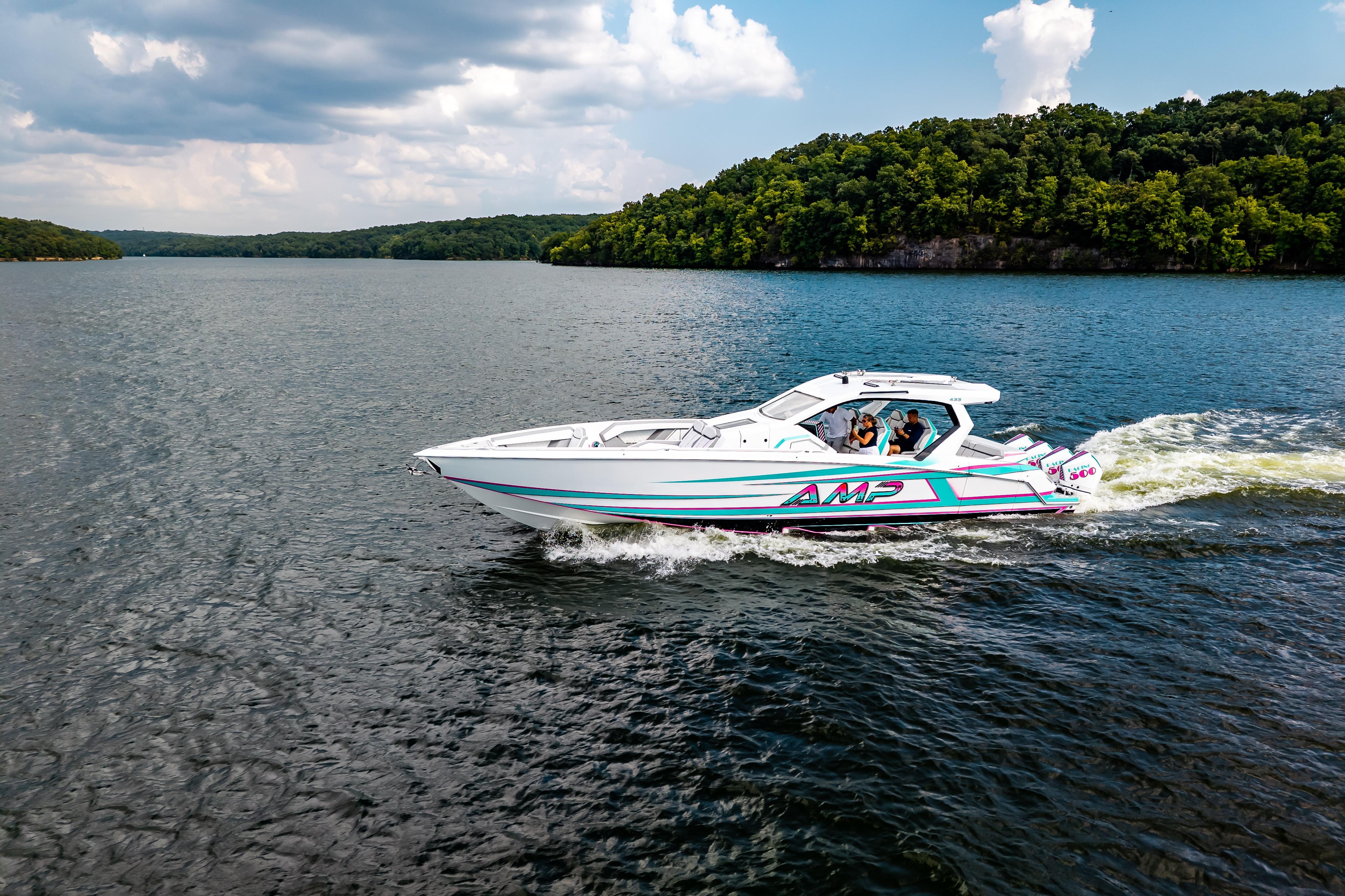 High-performance AMP 443 speedboat cruising on a scenic lake, 2025 model.