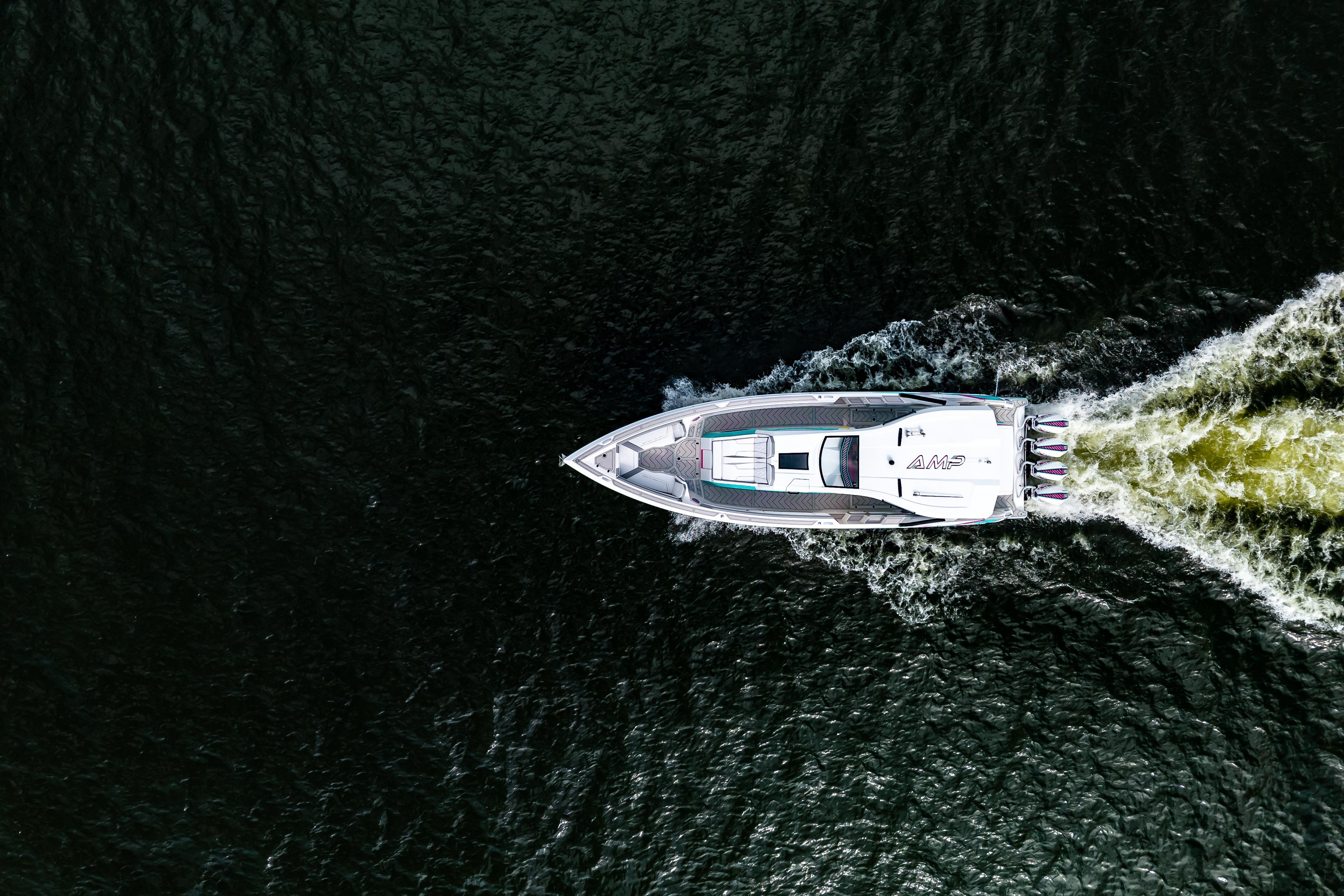 Aerial view of AMP 443 speedboat cruising on dark water, 2025 model.