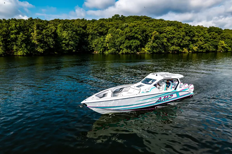  Yacht Photos Pics 2025 AMP 443 boat cruising on a serene lake with lush green forest backdrop.