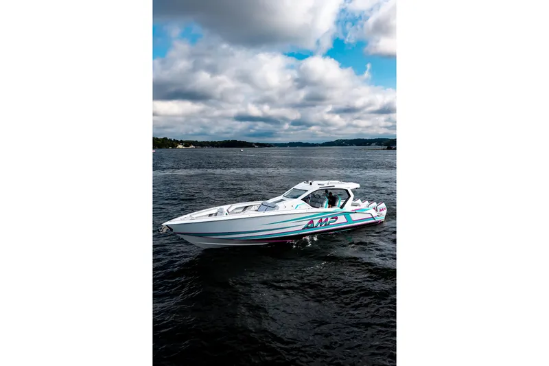 Yacht Photos Pics 2025 AMP 443 speedboat cruising on a lake under a cloudy sky.