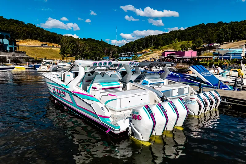  Yacht Photos Pics Futuristic AMP 443 speedboat docked, featuring multiple engines, vibrant design, and scenic waterfront backdrop.