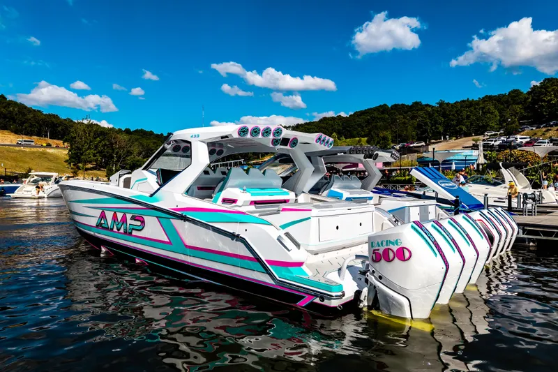  Yacht Photos Pics Futuristic 2025 AMP 443 speedboat with vibrant design docked on a sunny day.