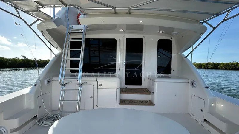 Sin Plan Yacht Photos Pics 2005 Bertram 630E yacht stern view with ladder and seating area.