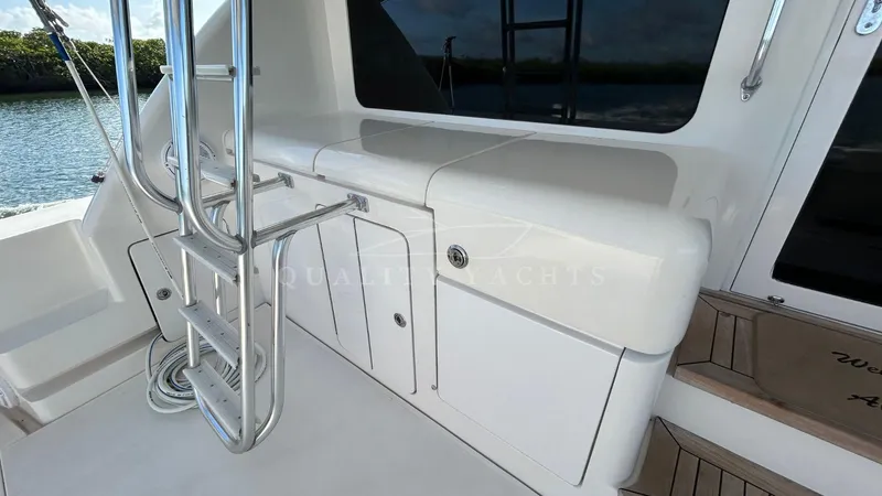 Sin Plan Yacht Photos Pics 2005 Bertram 630E yacht deck with storage compartments and ladder.