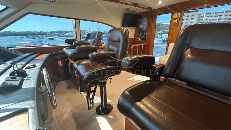 Sin Plan Yacht Photos Pics Interior of a 2005 Bertram 630E yacht with leather seating and panoramic windows.