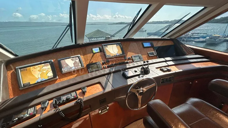 Sin Plan Yacht Photos Pics Helm station of a 2005 Bertram 630E yacht with navigation equipment and ocean view.