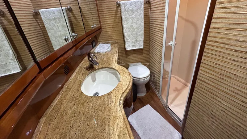 Sin Plan Yacht Photos Pics Luxurious bathroom in a 2005 Bertram 630E yacht with granite countertop and shower.