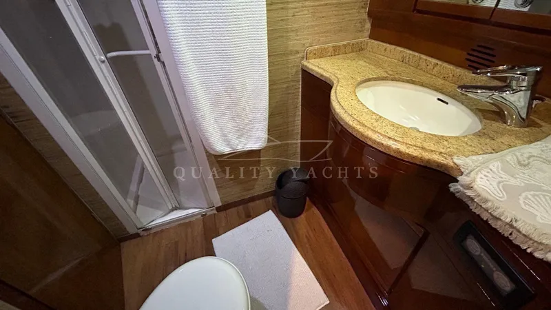 Sin Plan Yacht Photos Pics Luxurious bathroom in a 2005 Bertram 630E yacht with granite countertop and shower.