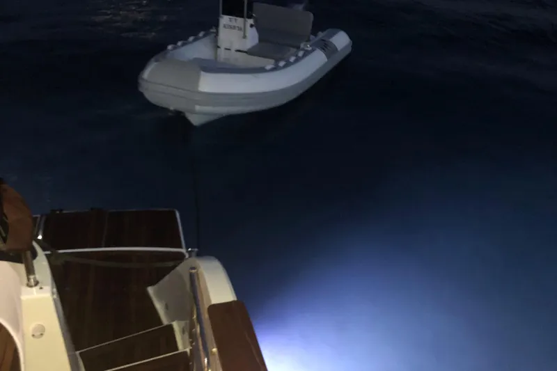 Kishta Yacht Photos Pics 2009 Fountaine Pajot Cumberland 46 yacht with tender boat at night, illuminated by underwater lights.