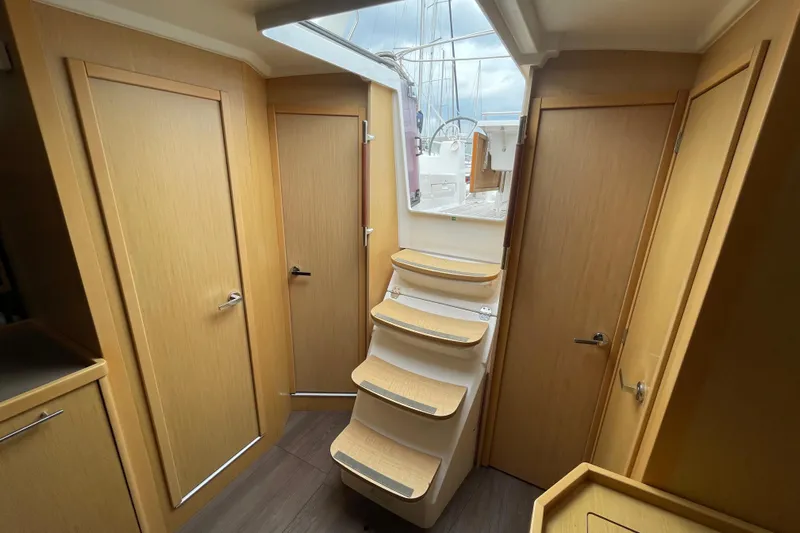 Moonshadow Yacht Photos Pics Interior of 2016 Beneteau Oceanis 38 sailboat with wooden doors and staircase to deck.
